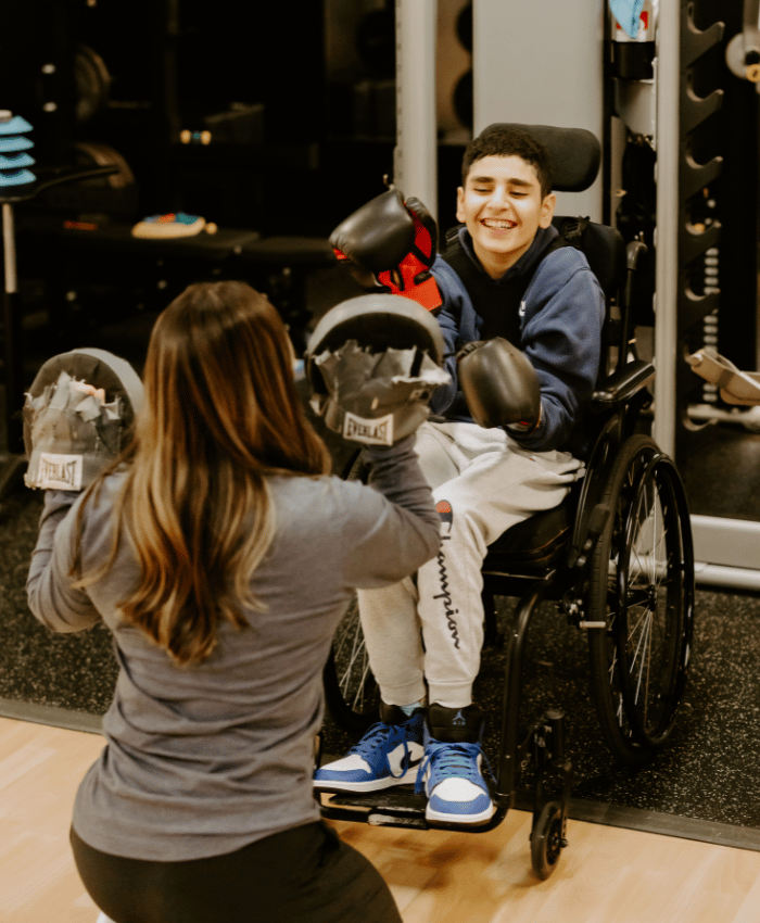 physical-threapy-client-in-wheelchair-doing-PT-exercise-with-physical-therapist