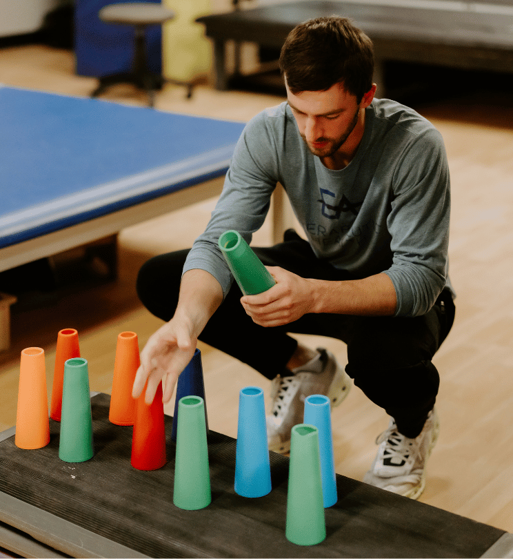 Volunteer at physical therapy clinic helps set up equipment
